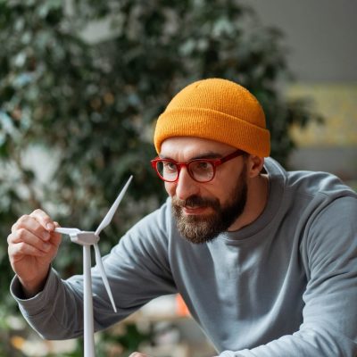 engineer-examining-small-wind-turbine-model-for-renewable-energy-project.jpg